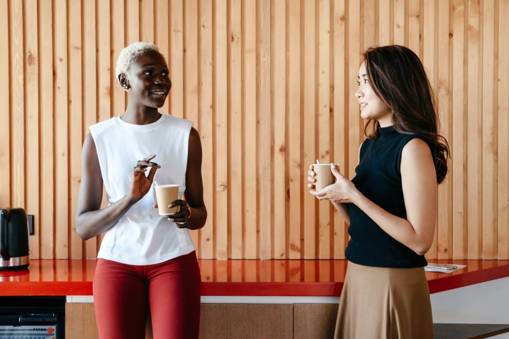 Diverse women with takeaway coffee in office