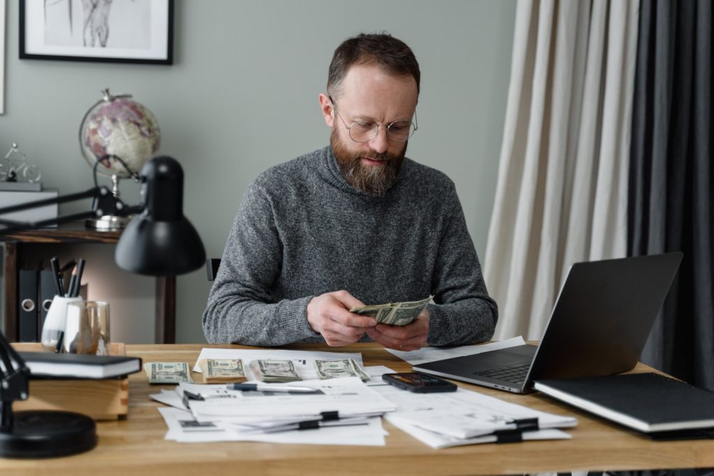 Business owner working on his own accounting and counting cash