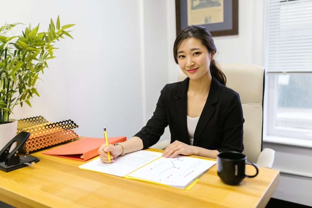 A female accountant sitting at a table in a black suit