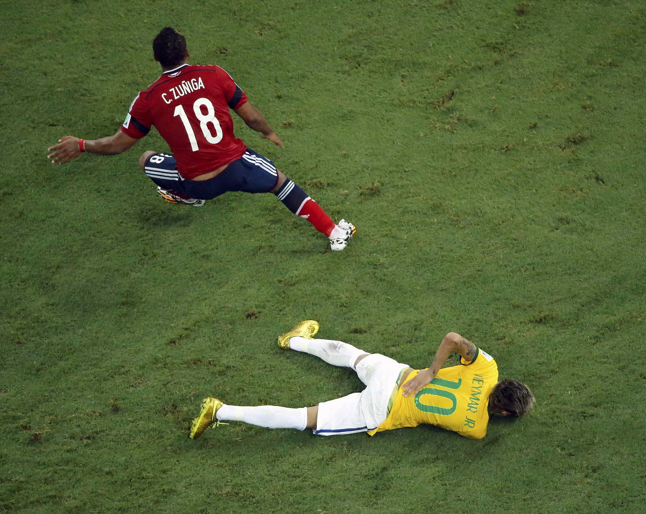 Brazil's Neymar lies on the ground injured after a challenge by Colombia's Zuniga during their 2014 World Cup quarter-finals at the Castelao arena in Fortaleza