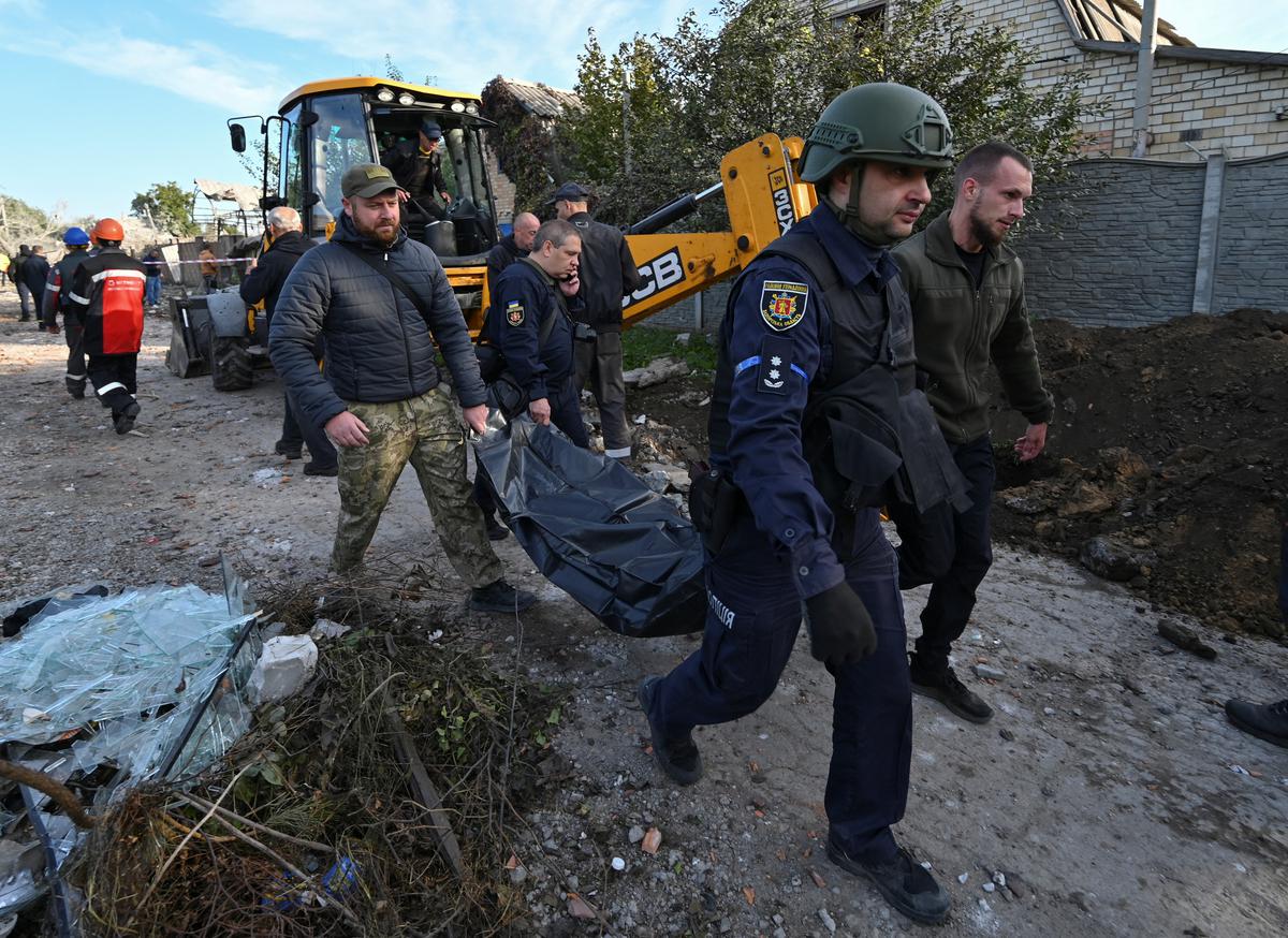 Несут тело погибшего в результате обстрела Запорожья 9 октября