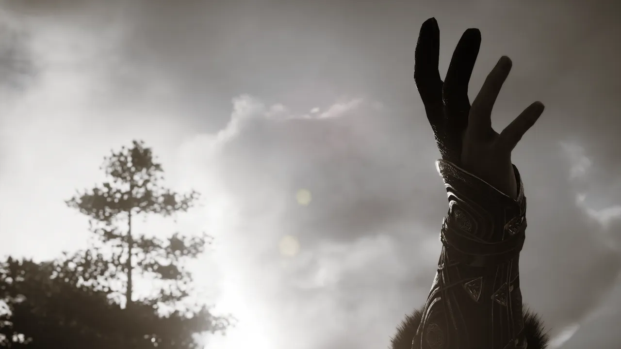Close up on human hand with armoured bracer and glove against the sky with a blurred tree.