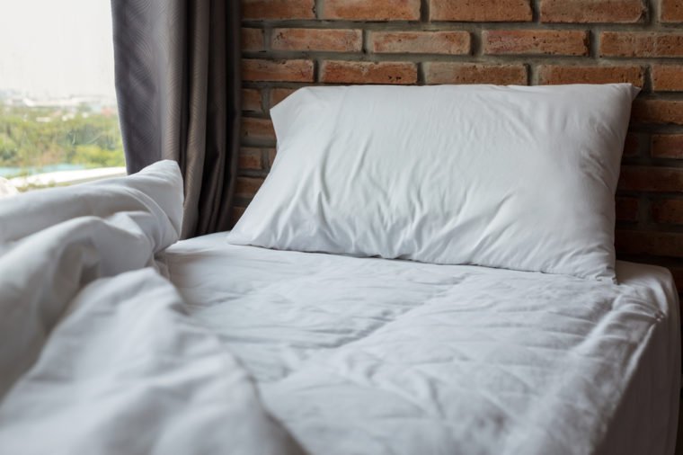 close up of pillow on the bed with brick background.