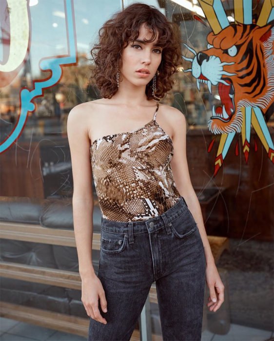 Chica con el cabello chino y posando para una fotografía 