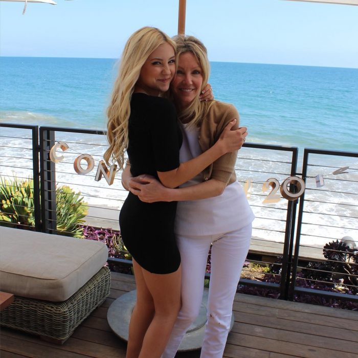 Madre e hija de cabello rubio abrazadas y sonriendo frente al mar, Ava Sambora y Heather Locklear