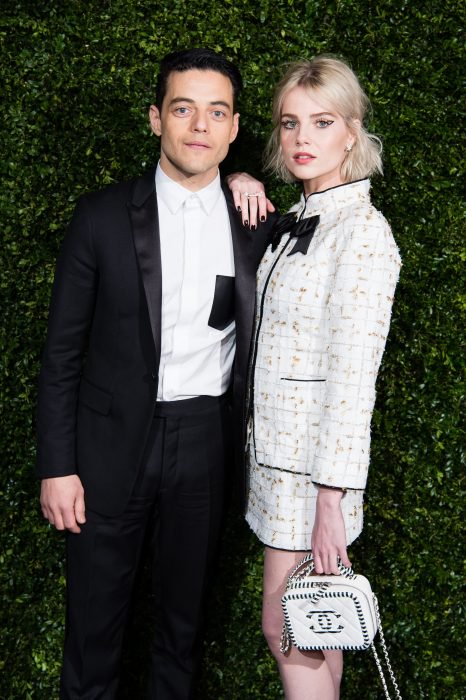 Rami Malek y Lucy Boynton abrazados posando para una foto durante la alfombra roja de la pasarela de Chanel 