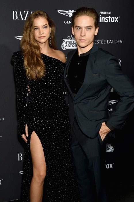 Dylan Sprouse y Barbara Palvin abrazados y posando para una foto en una alfombra roja 