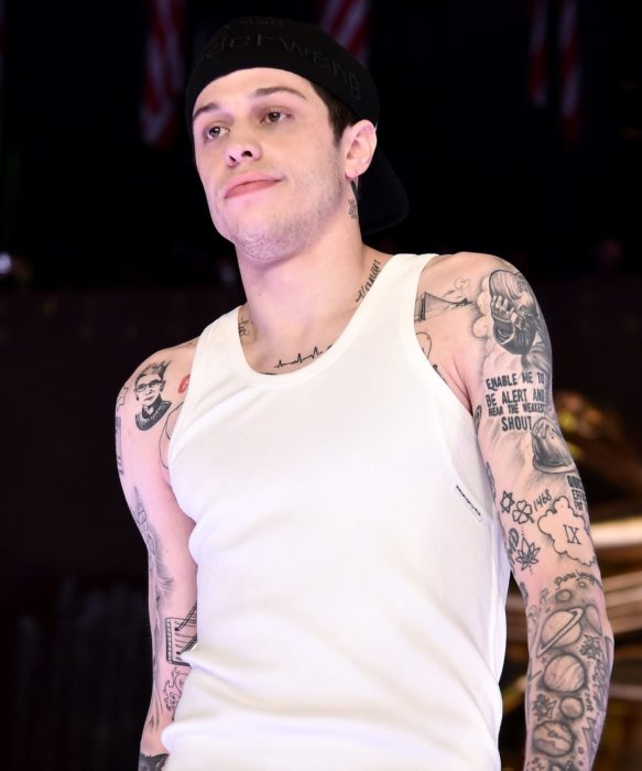 Pete Davidson con playera de tirantes blanca y enseñando sus tatuajes