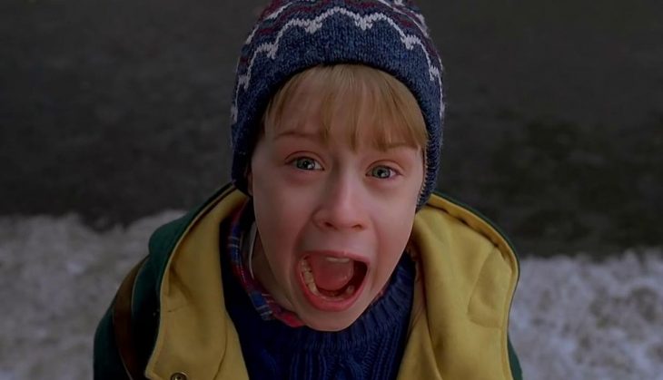 Niño rubio con gorro de invierno gritando