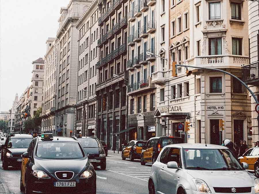 Taxis y coches en una calle céntrica de Barcelona de día, con edicifios del estilo del Eixample