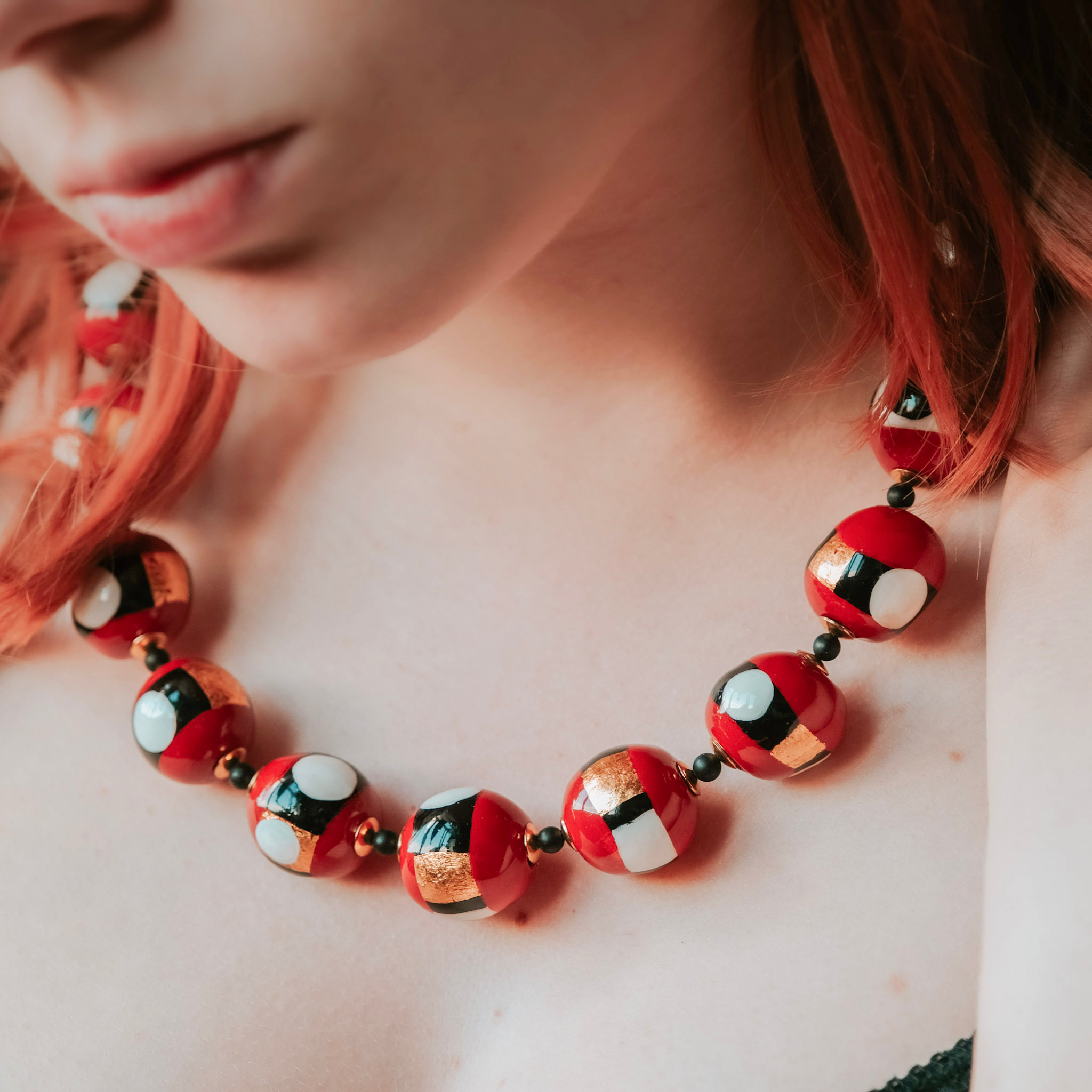 Collier de perles d'argile rouge, blanc, noir et or