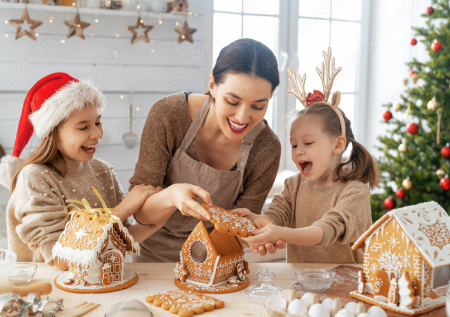 madre e hijas cocinando casas de jengibre