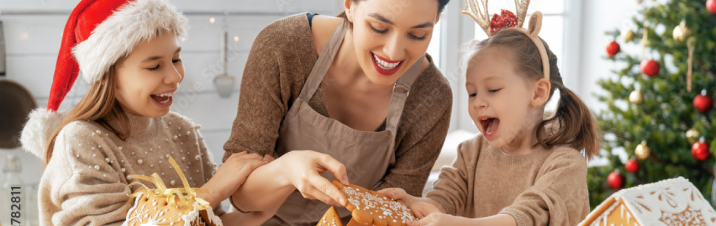 madre e hijas cocinando casas de jengibre