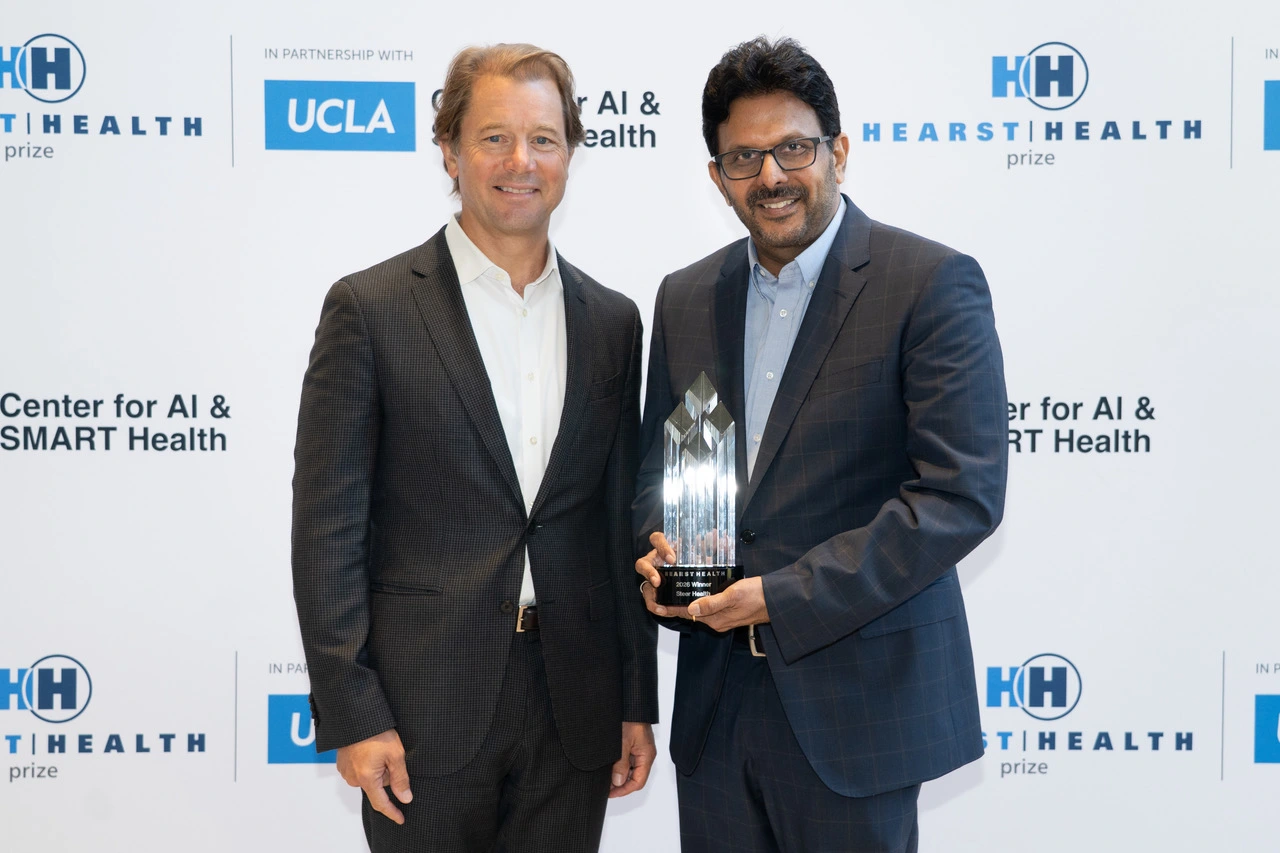 Greg Dorn and Sridhar Yerramreddy holding the 2026 Hearst Health Prize trophy