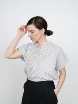 Cap sleeve shirt with vertical stripes, worn by a woman, side view.