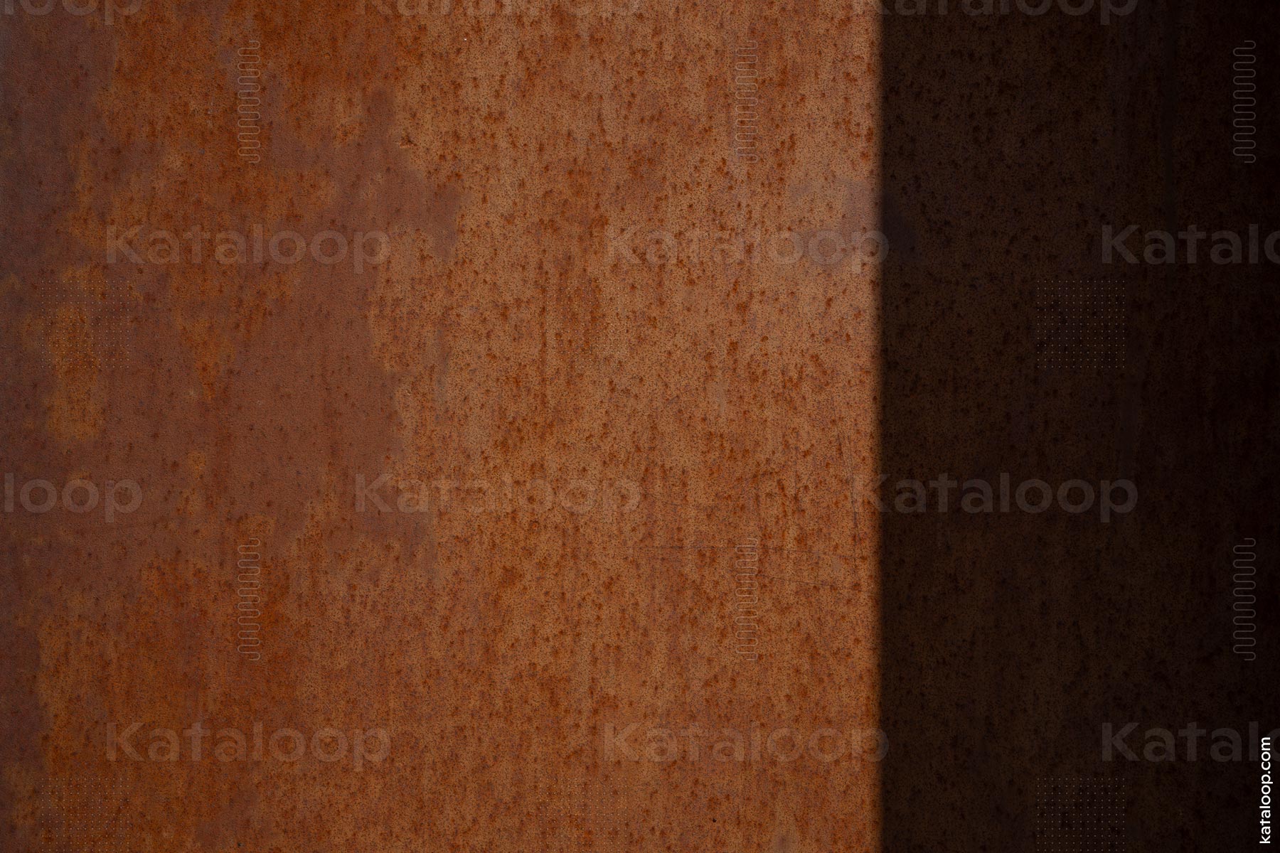 This image showcases a close-up view of a rusted metal surface with a distinct texture. The play of light and shadow adds depth to the corrosion and creates a gradient effect across the material.