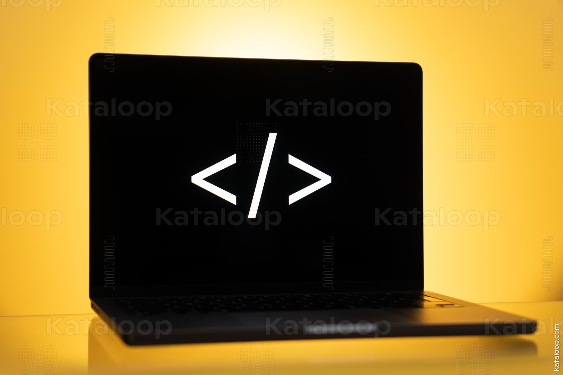 This image features a close-up view of a laptop screen displaying a pair of angled brackets commonly used in HTML coding. The screen is illuminated with a bright white light against a dark background, creating a strong contrast. The laptop is set against a vibrant yellow backdrop, emphasizing the theme of technology and coding.