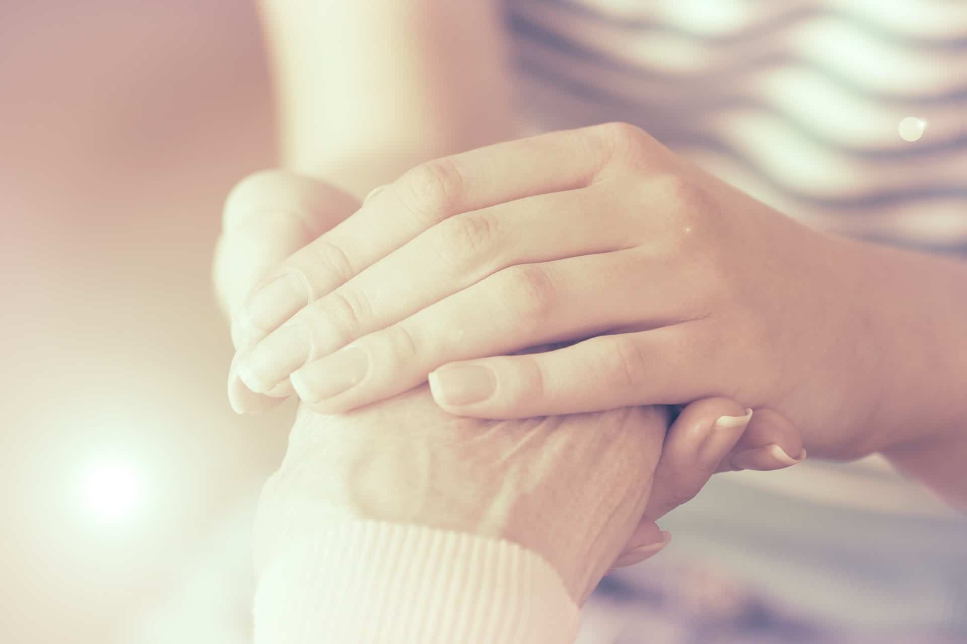 Woman holding a loved ones hand.