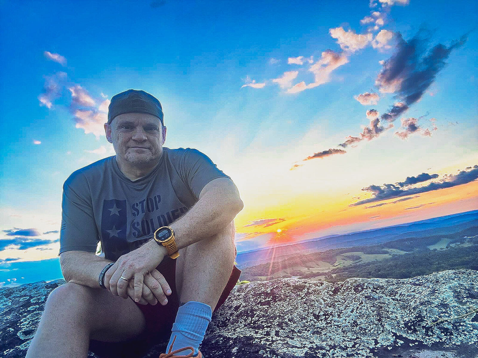 Chris Stephens sitting in front of a beautiful sunset