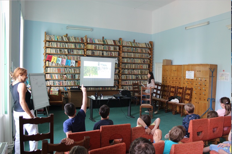 Amelia narrating The Magic Mango at a local library in her hometown to a group of very engaged children