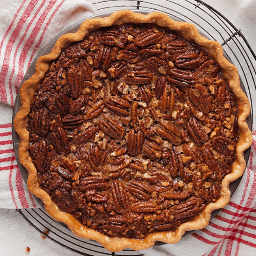 pecan pie from the top down with a plate and kitchen towel underneath