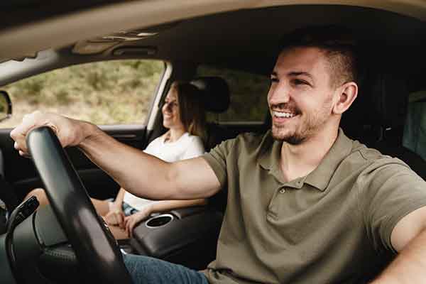 couple dans une voiture occasion et l'homme conduit