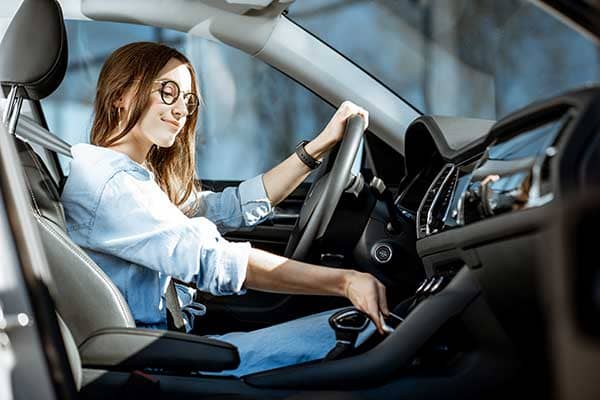 femme brune qui conduit une voiture