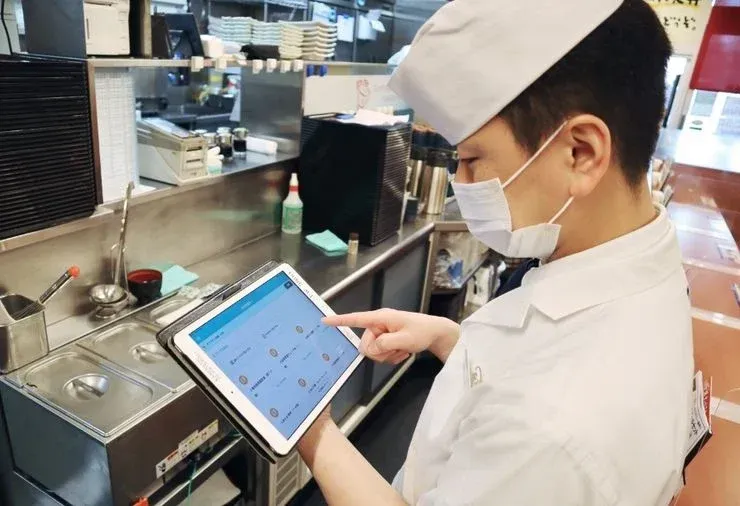 店舗でカミナシ レポートを使用している様子