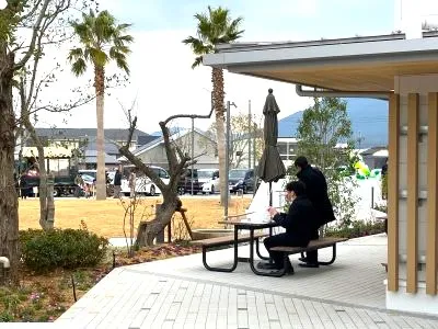 建物のデッキと後方は芝生広場