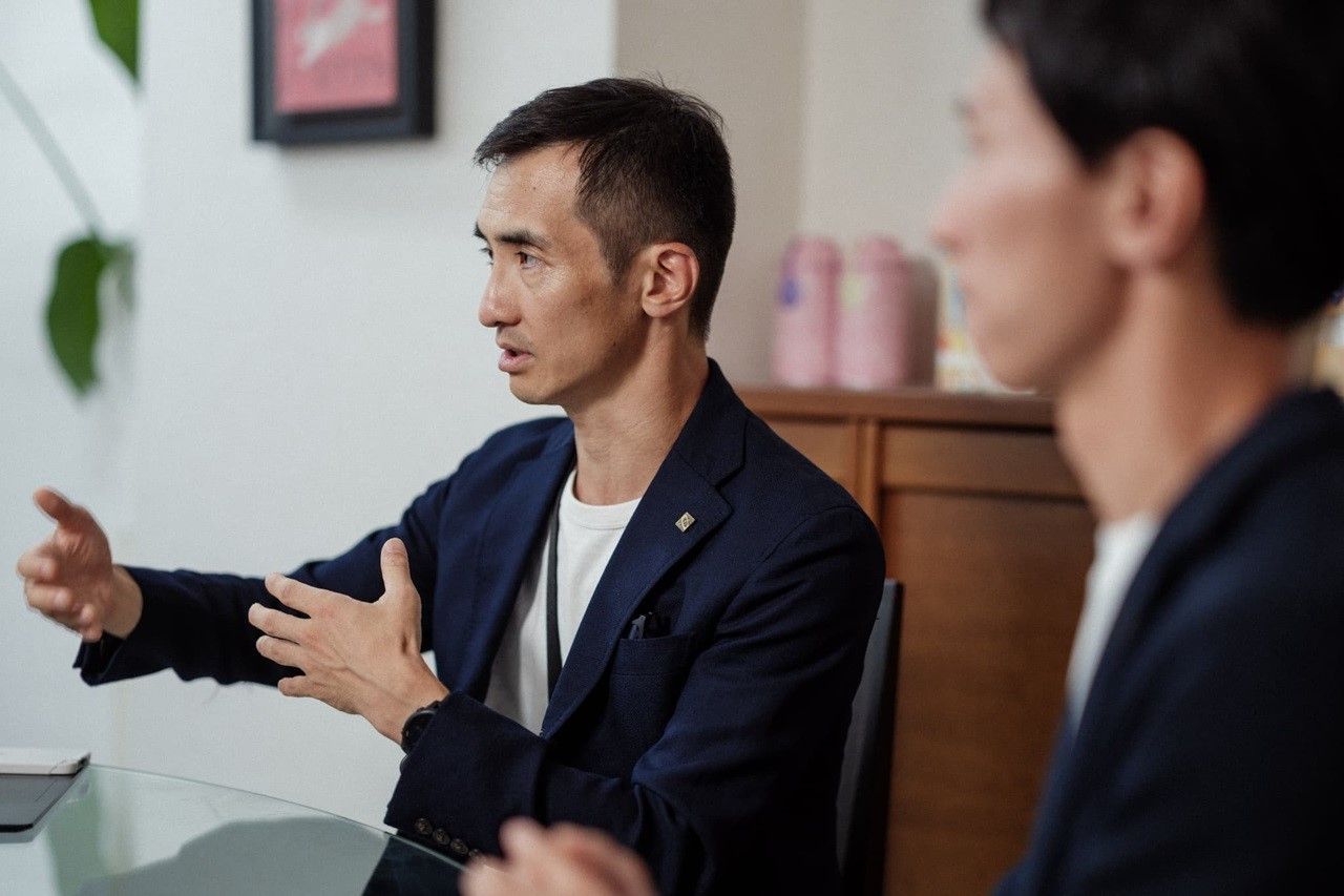 座って語る野﨑氏と手前側に座る山田氏