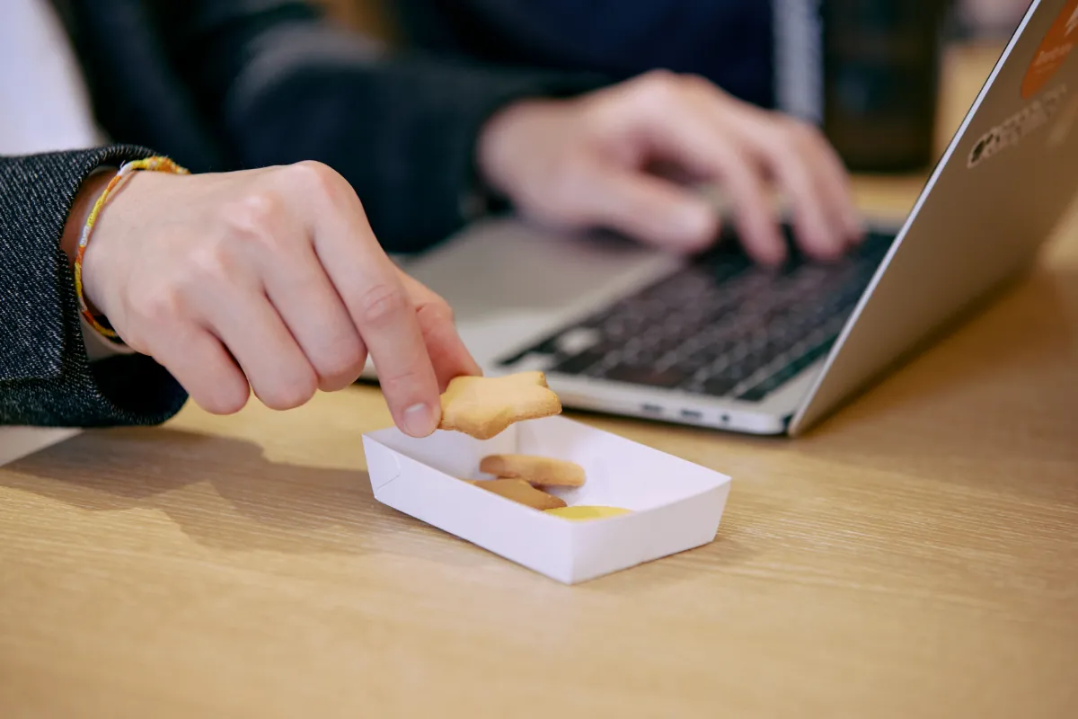 PC作業のかたわらスナックミーのお菓子をつまむ手