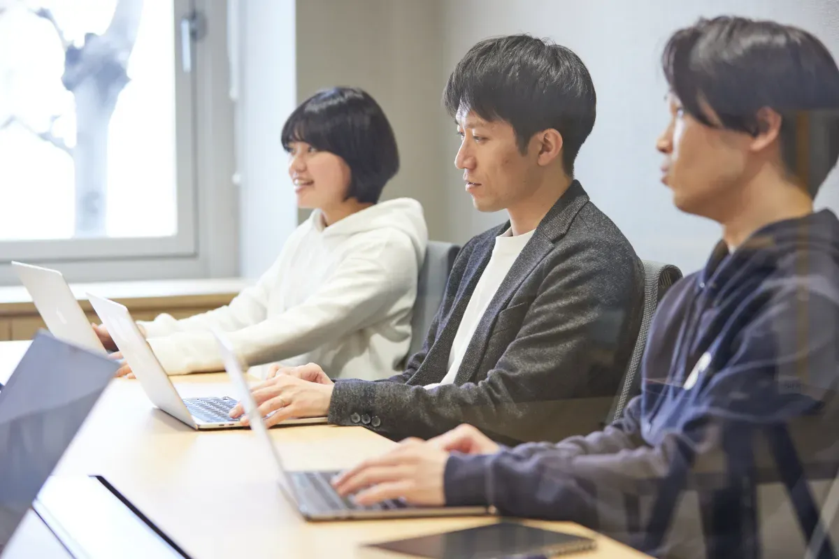 オフィスの会議室でテーブルに向かう従業員たち