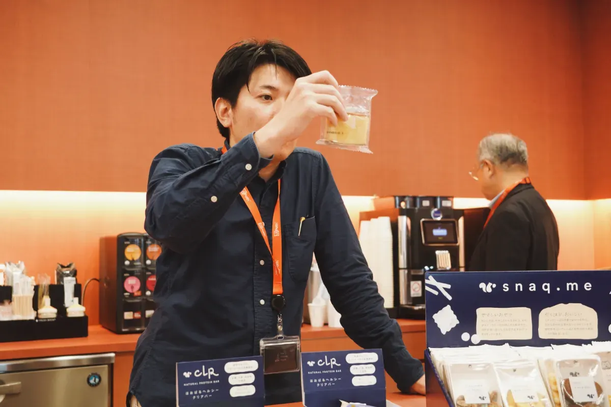 スナックミーオフィス導入企業『UiPath株式会社』さまのスタッフが、スナックミーの焼き菓子のパッケージを見る様子