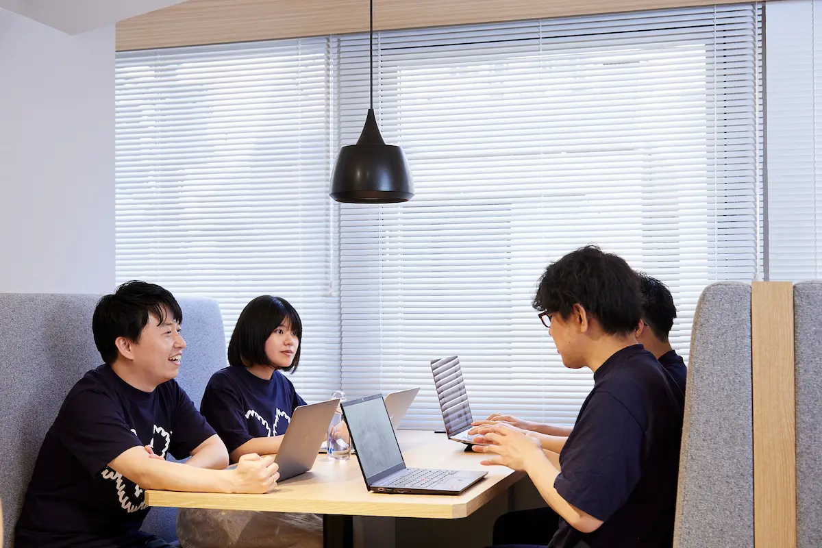 ソファーで向かい合わせに座り談笑する人たち