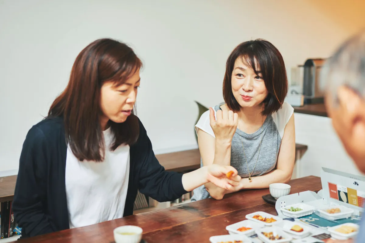 おやつを食べながら話す女性2人