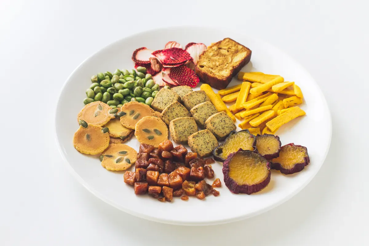 お皿に並べられた、スナックミーオフィスの焼き菓子、ドライフルーツ、野菜スナック