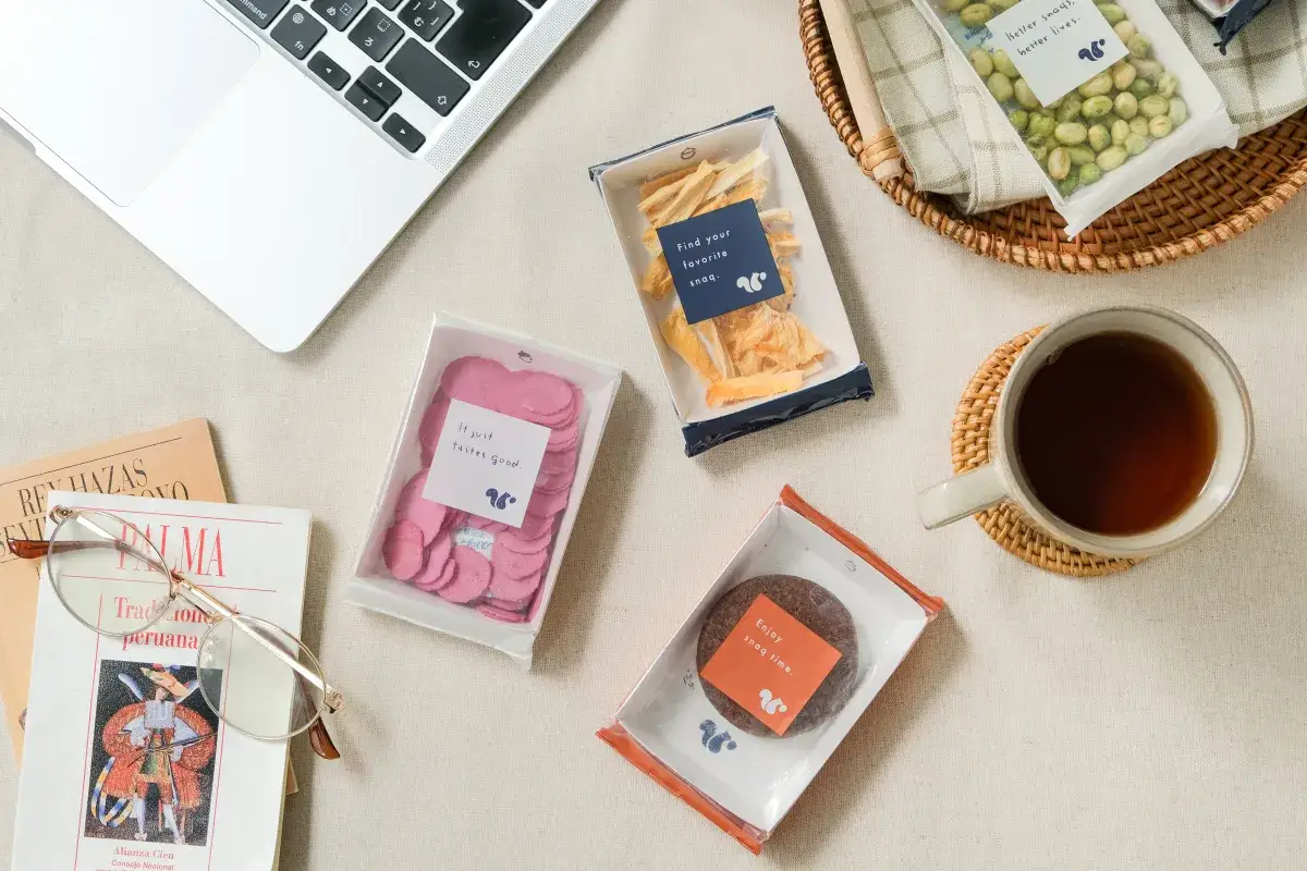 PCの横に置かれたスナックミーのお菓子とコーヒー