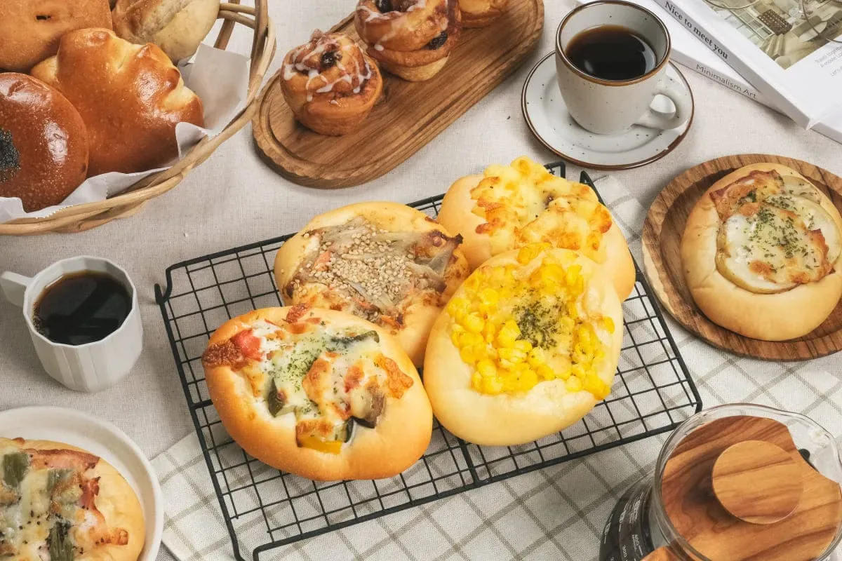 テーブルに並べられた惣菜パン・甘いパンとコーヒー