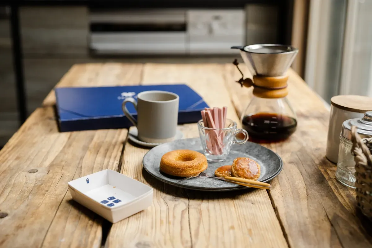 スナックミーのお菓子(焼き菓子やチョコレート)とコーヒー用具が置かれたテーブル