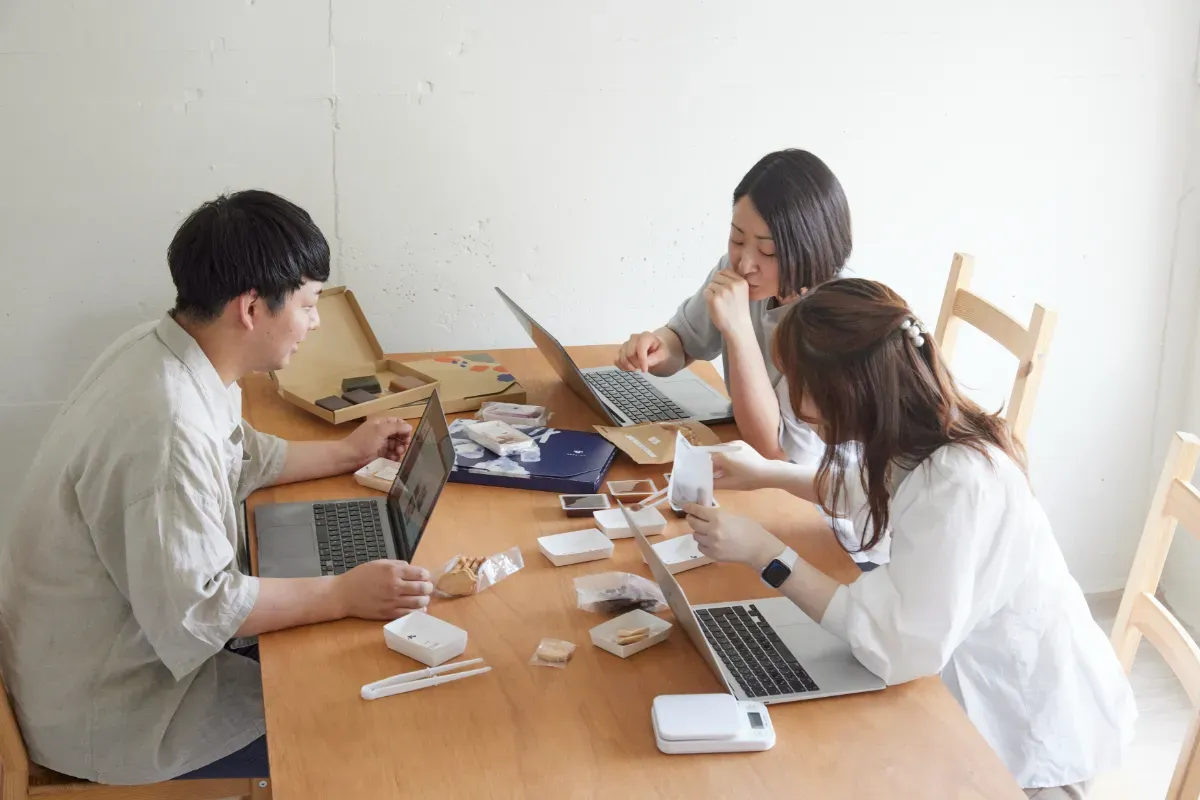 従業員が商品や資材を囲んで打ち合わせをする様子