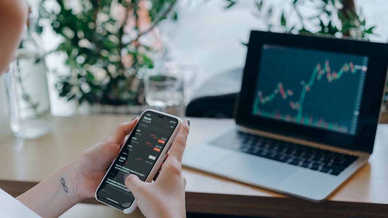 スマホとパソコンで投資用の株価を見ている画像