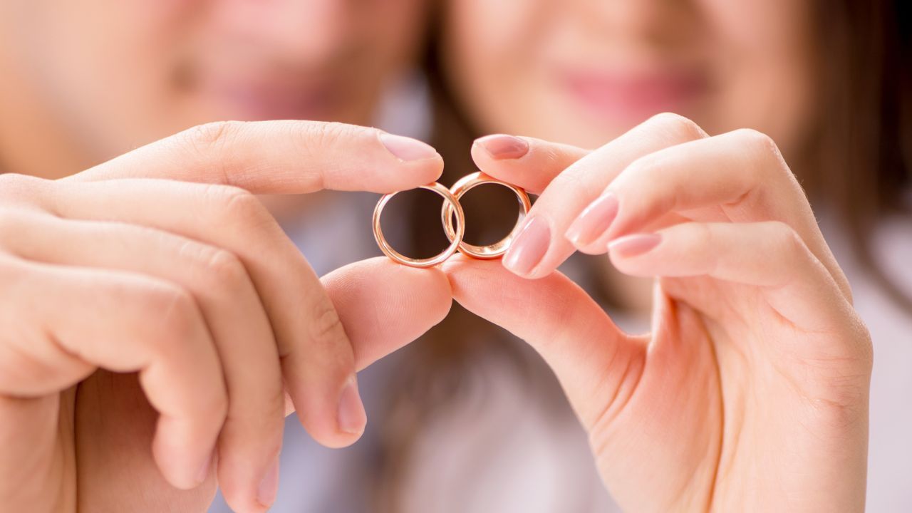 結婚指輪を重ね合わせる男女の画像