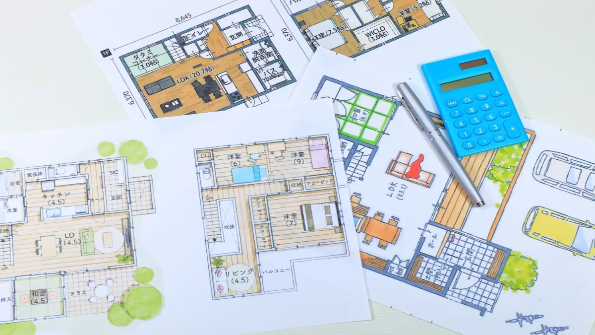 家の間取り図と電卓が置かれている様子。
