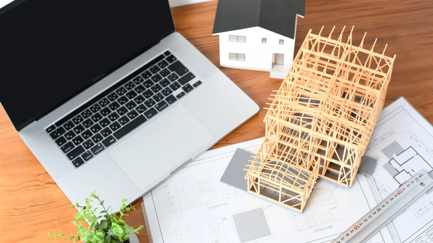 建築模型とノートPCと建築図面のイメージ