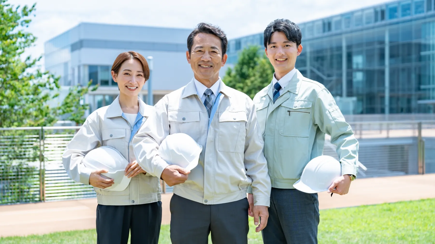 ヘルメットを持つ作業着の男女