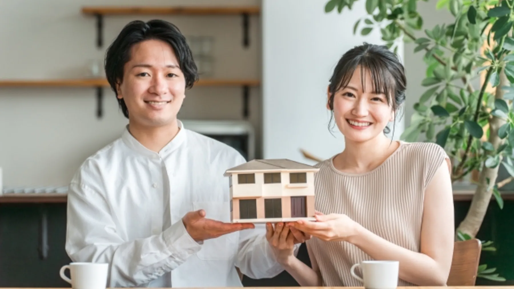 若い男女が住宅の模型を持っている様子