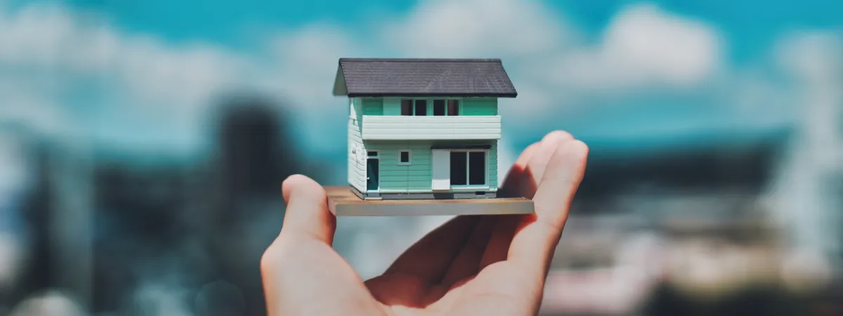 家の模型を持っている手