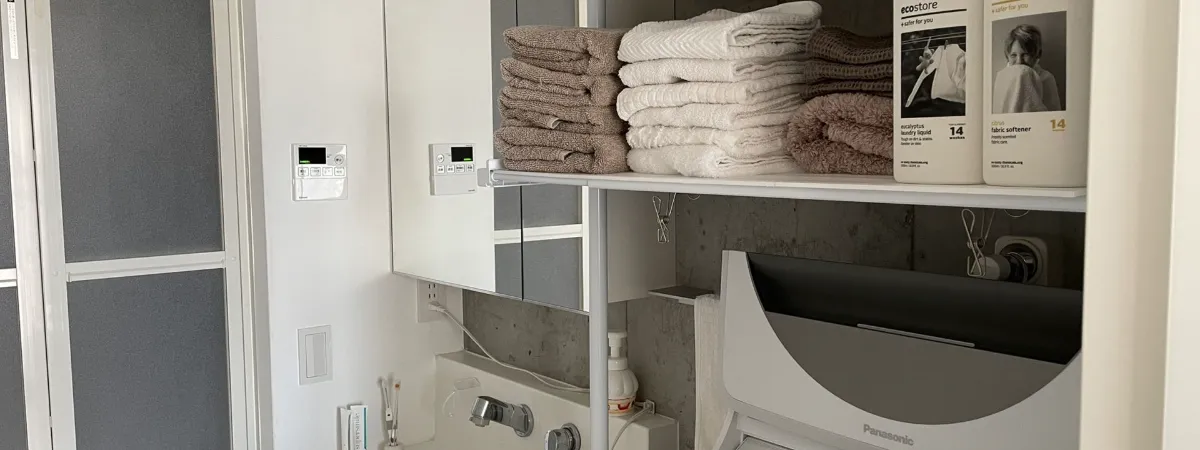 白いタオルが整然と収納された洗面所の棚