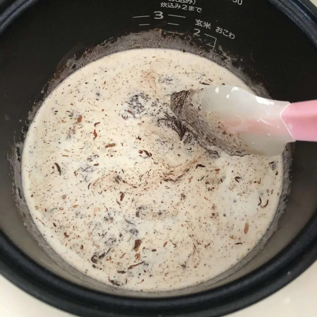炊飯器の釜で溶かしチョコレートと生クリームを混ぜる様子