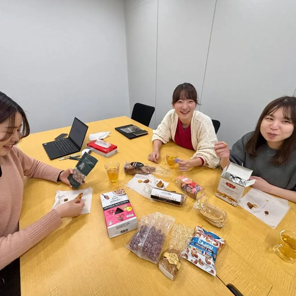 スナックミーの商品開発スタッフが、パリのお土産のお菓子の試食会を開き、研究している様子。